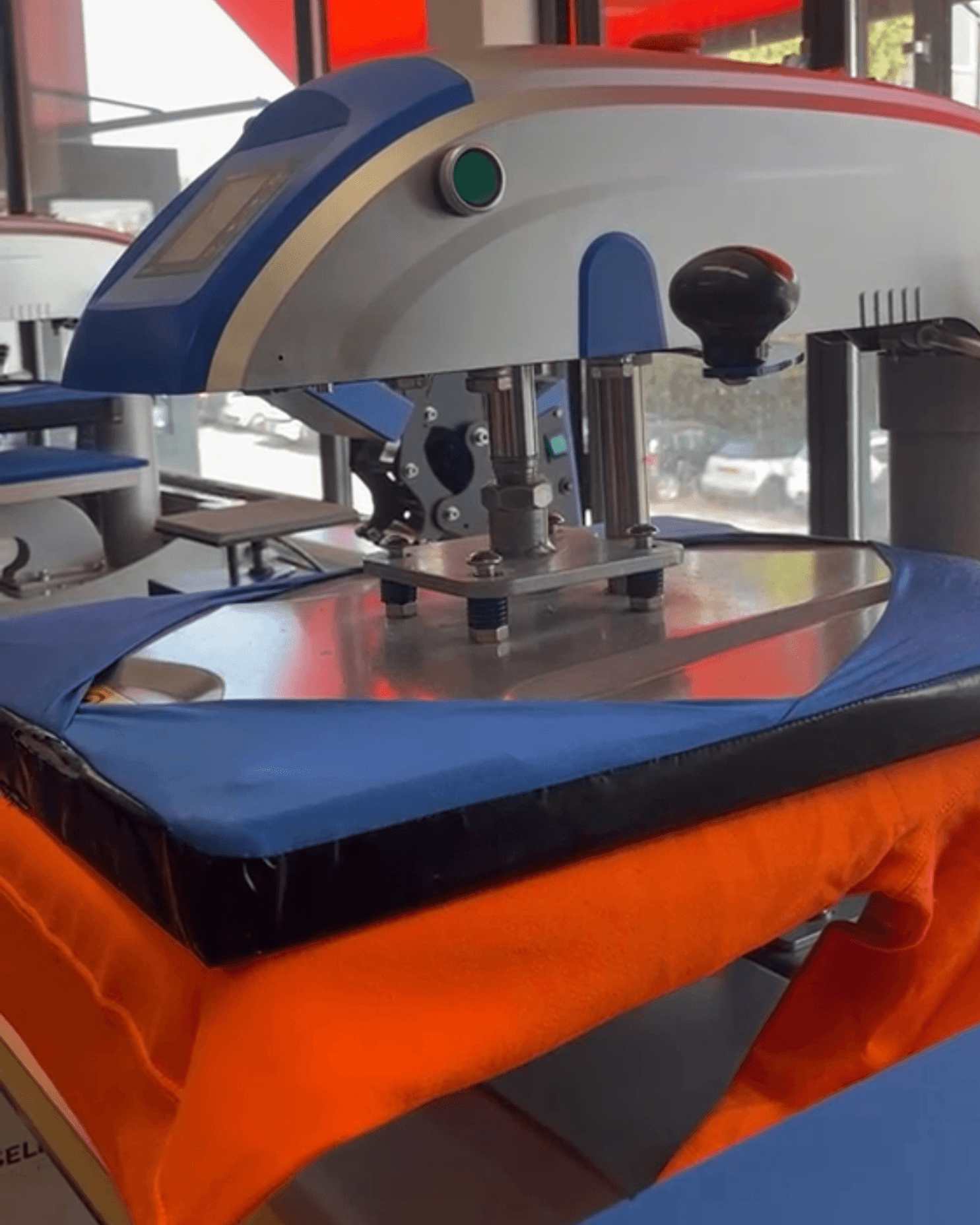 Het bedrukproces: een heat press die een oranje shirt bedrukt